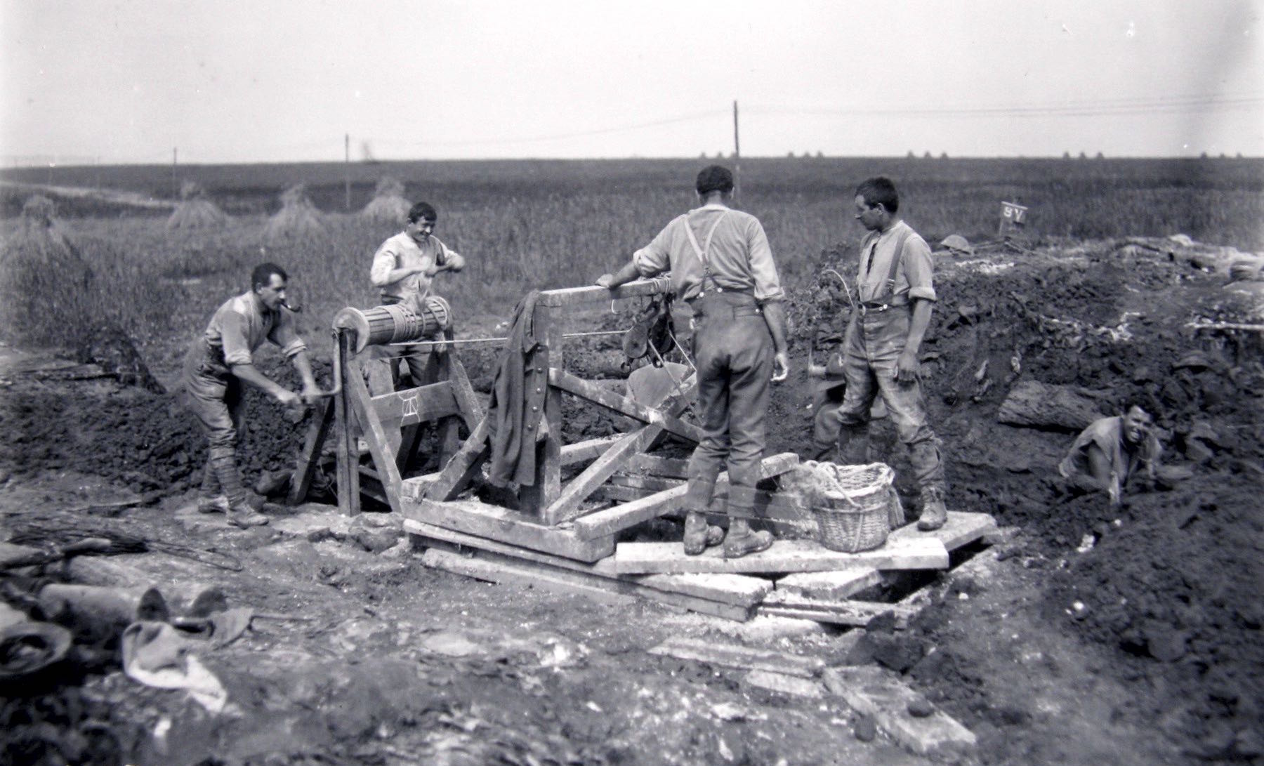 A group of four men working at the surface of a dug-out entrance